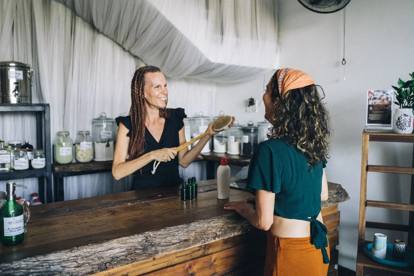 A shop owner serving a local customer from behind the counter