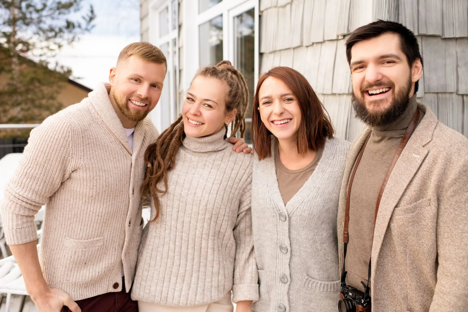 Four team members smiling together, real faces and names instead of stock photos