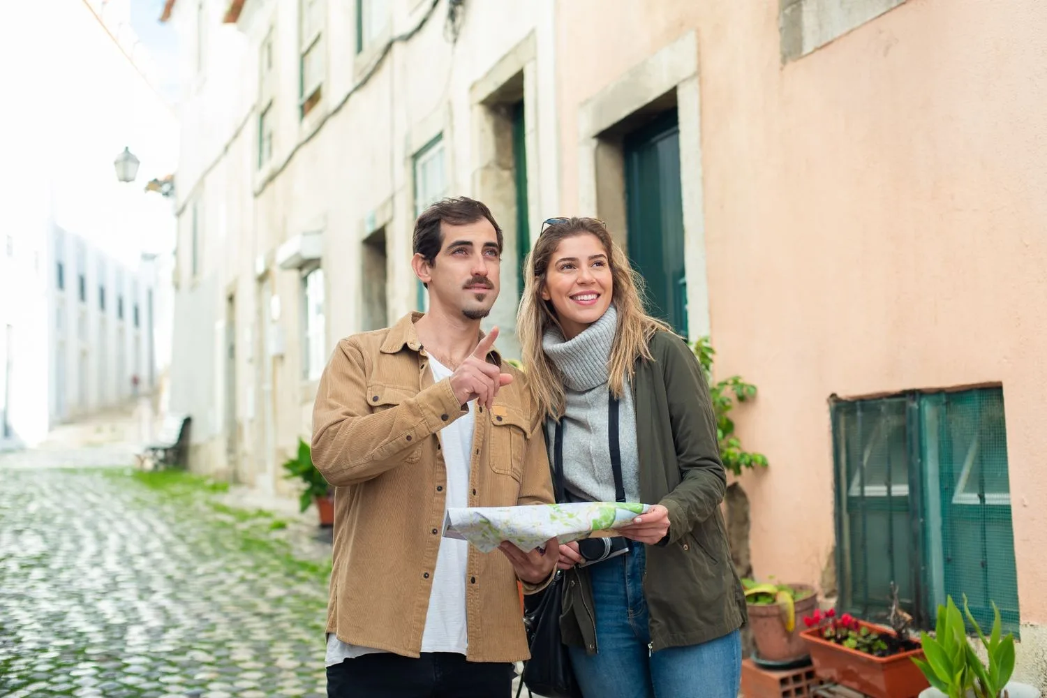 Turistes amb un mapa en un carrer d'un poble mediterrani, buscant on anar pel nom de la cala