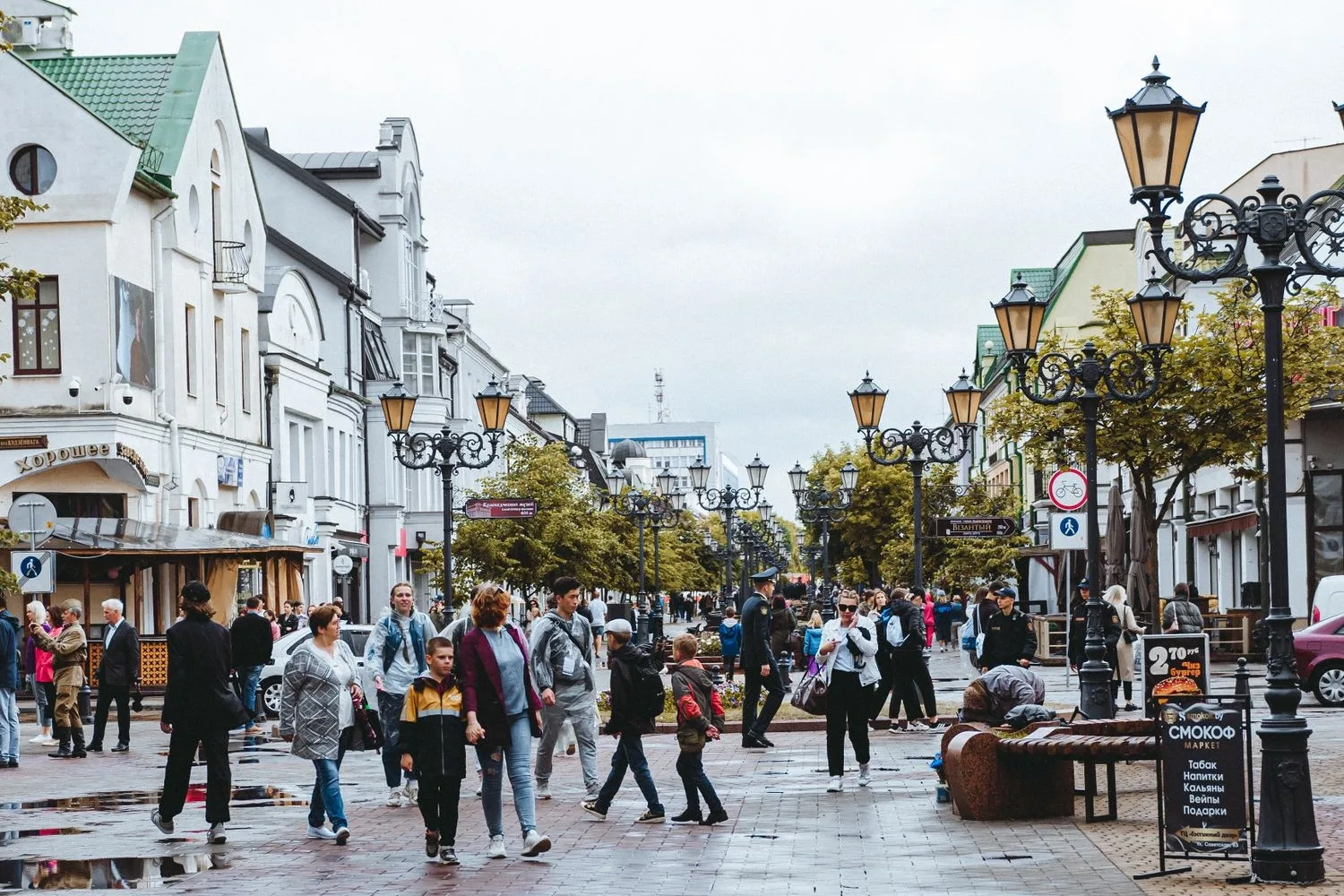 A neighbourhood street with shops and people walking mid-morning