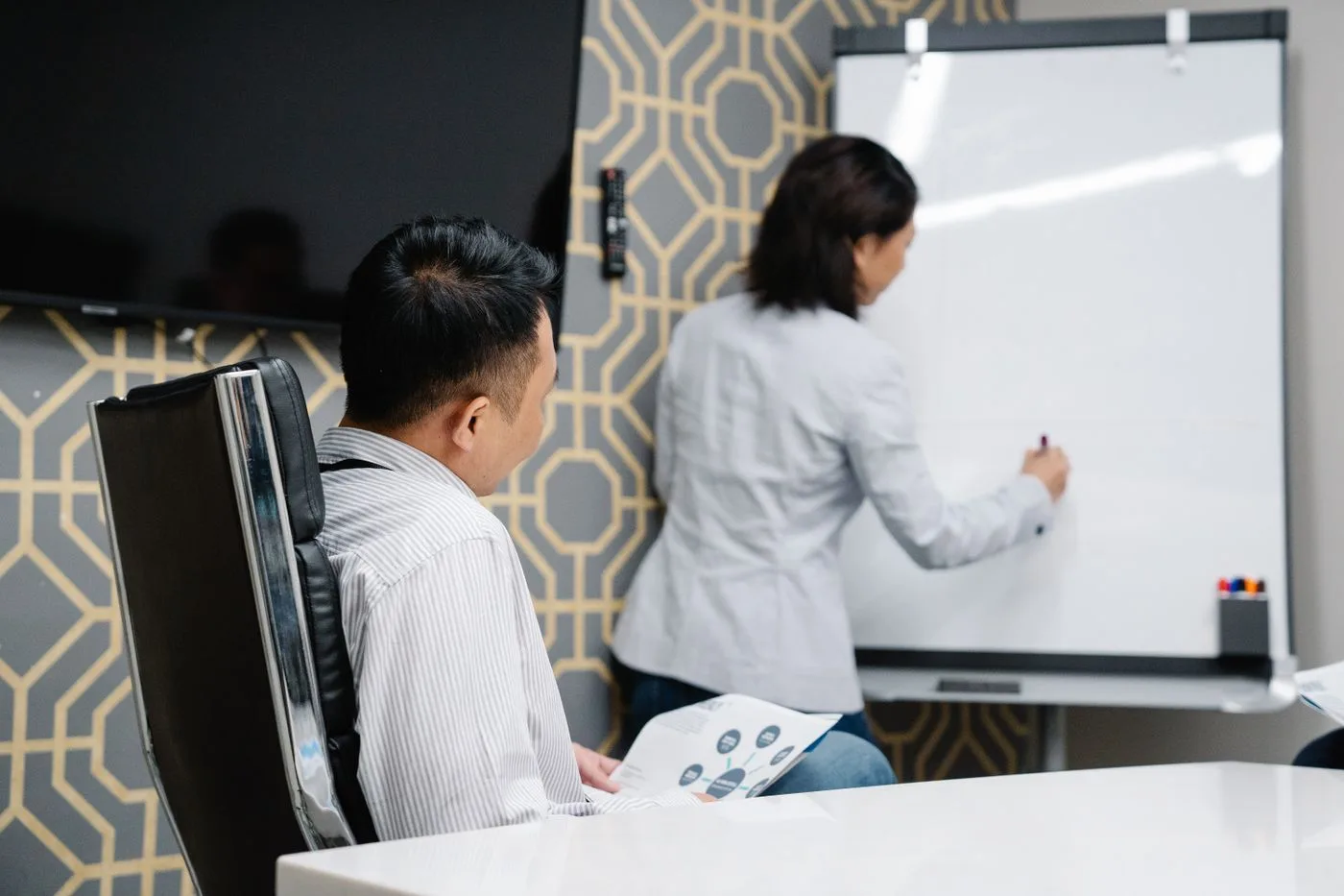 Two people at a whiteboard deciding which pages the website will have