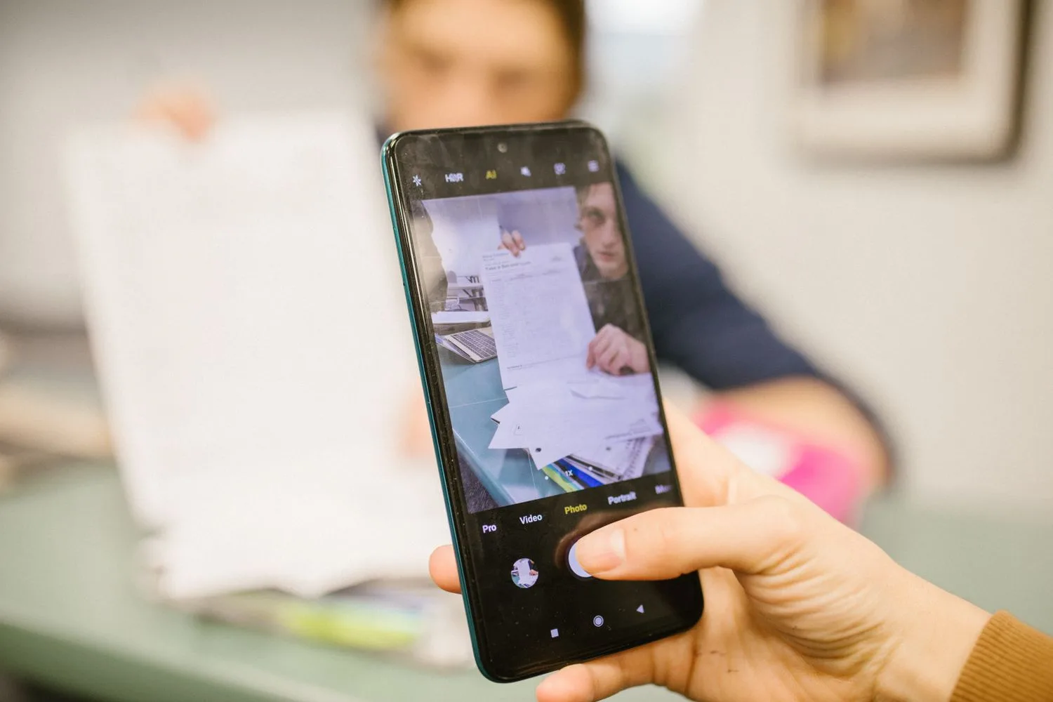 A document being photographed with a phone to send it to the office