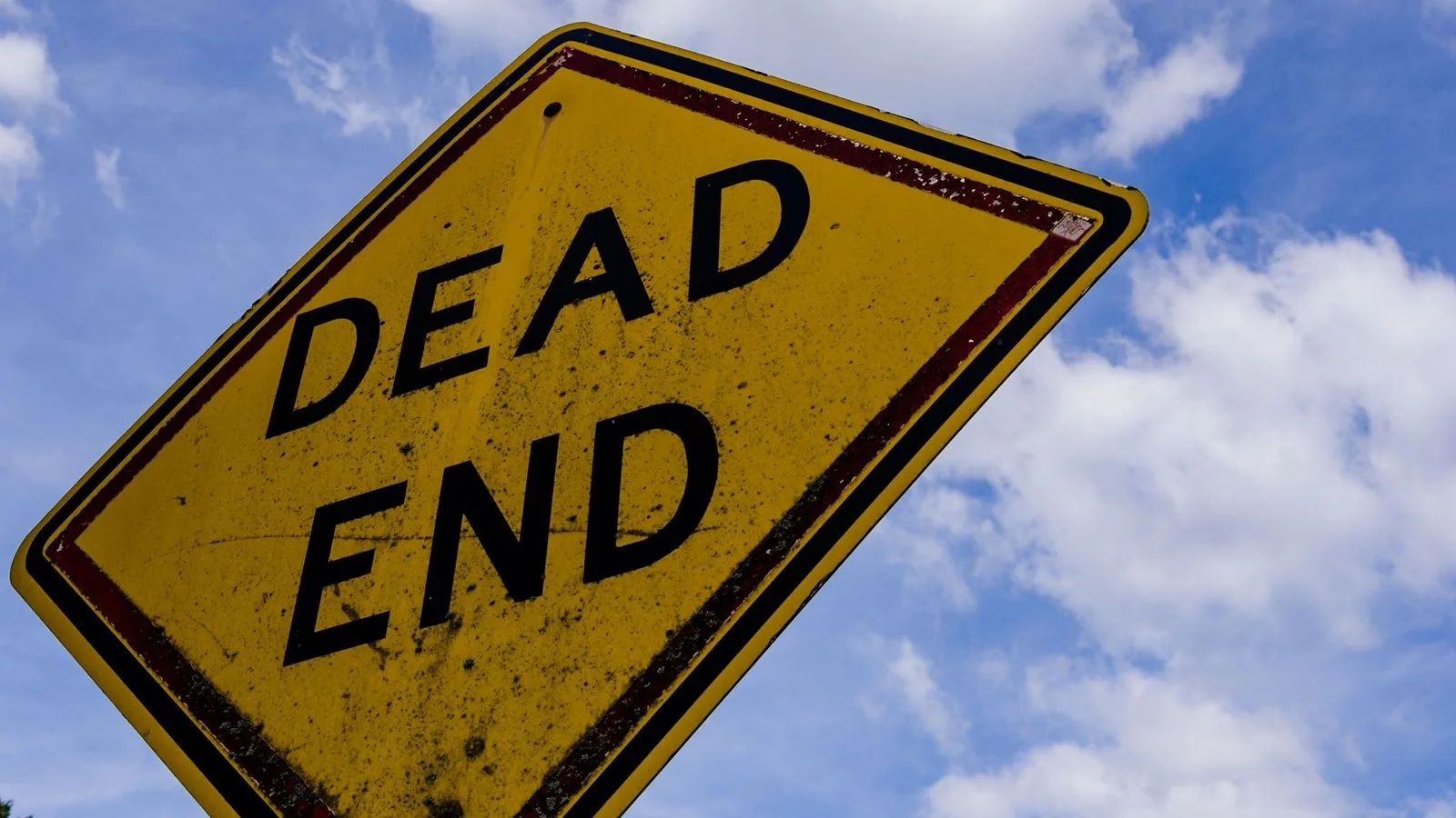 Un senyal groc de carrer sense sortida («Dead End») contra un cel blau amb núvols, la sensació que deixa un error 404