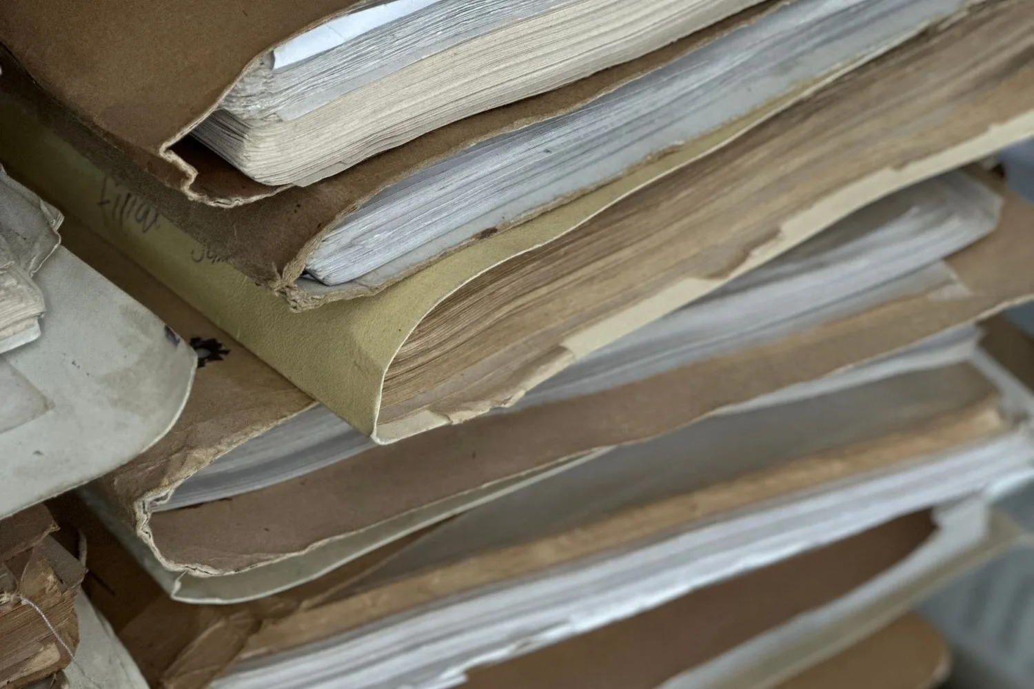 Stacks of worn paper case files, before going digital