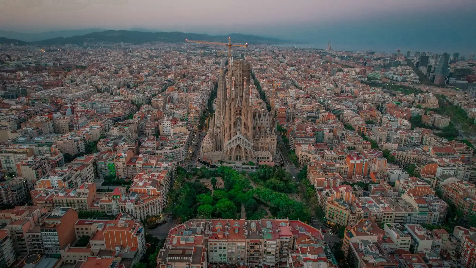 Vista aèria de Barcelona al capvespre amb la Sagrada Família i les illes de l'Eixample, la ciutat on es reparteixen els anuncis de Google Ads a Barcelona