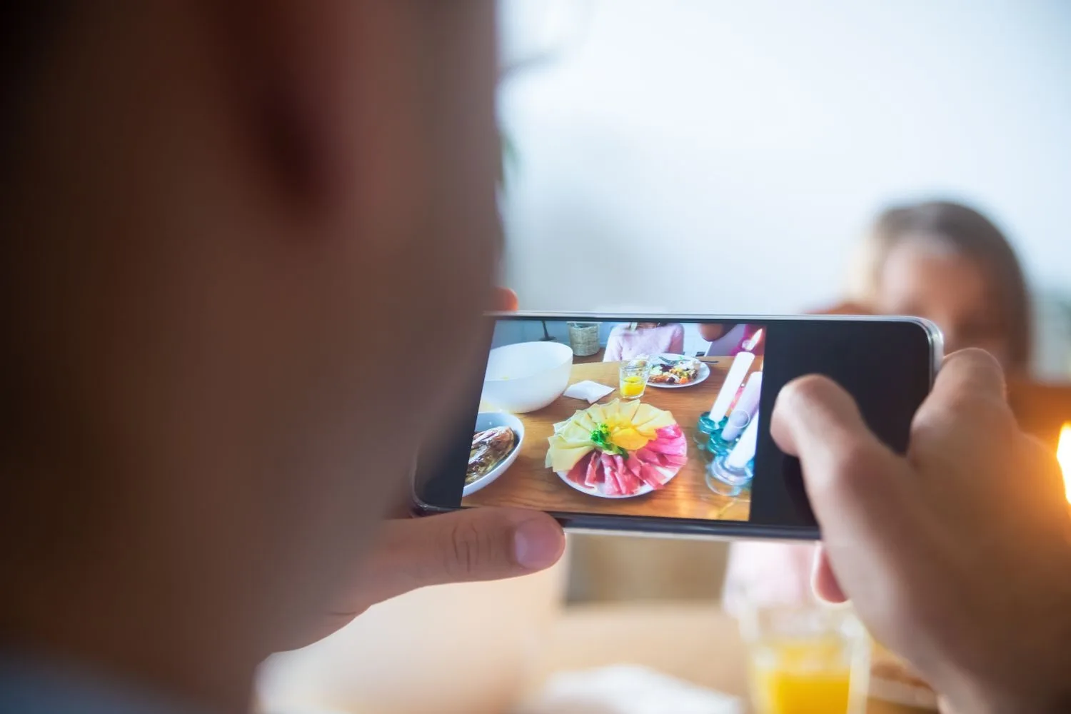 Haciendo con el móvil la foto de una mesa servida para la web del negocio