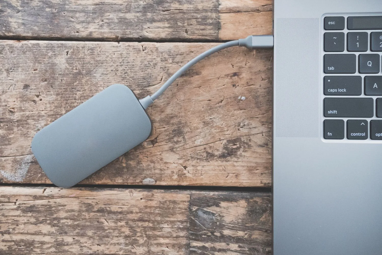 An external drive plugged into a laptop to store the website backup