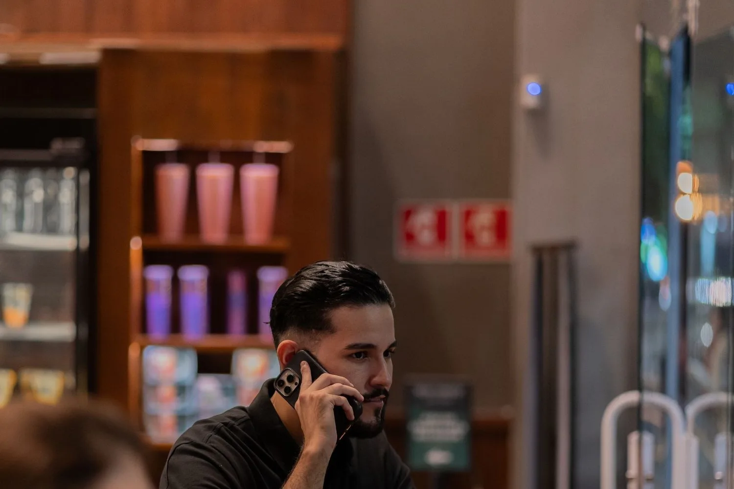 Agafant el telèfon a la barra mentre hi ha clients esperant