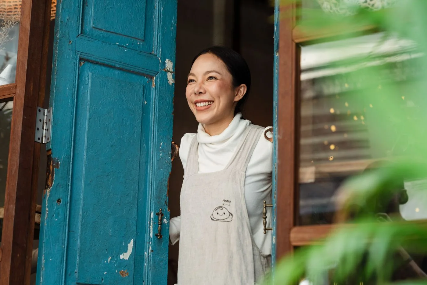 A small shop owner in her doorway, relaxed, with the website up to date
