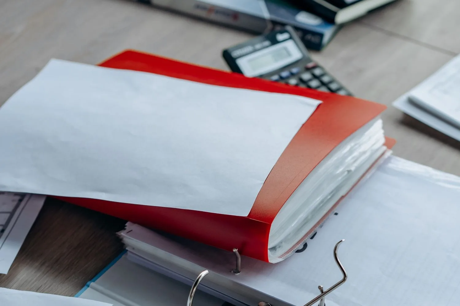 Factures i albarans damunt la taula que algú passa a mà al programa de gestió