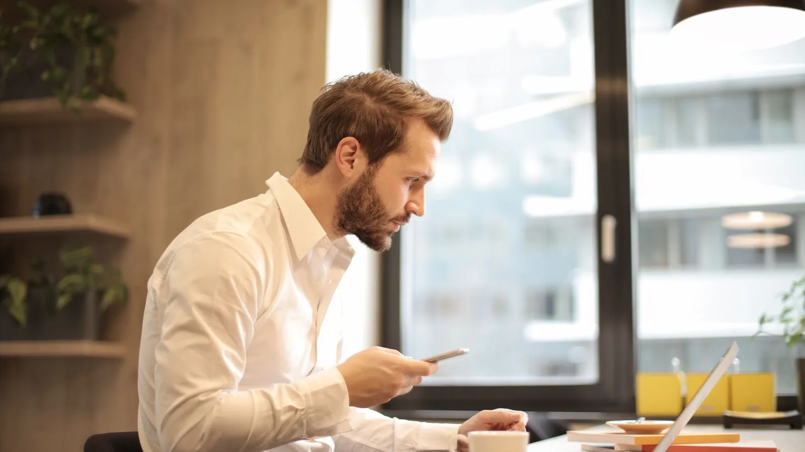 Someone typing a question into an AI assistant on their phone to get a business recommendation