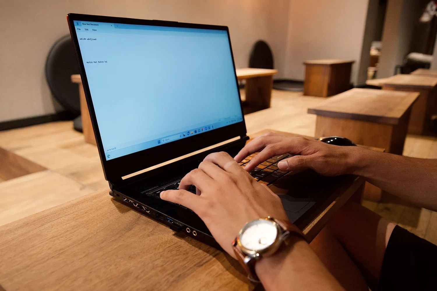Hands typing on a laptop the questions people type before deciding