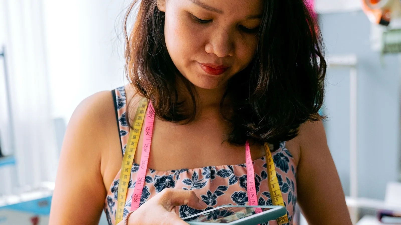 Dressmaker photographing her finished work with the phone to post it on her listing