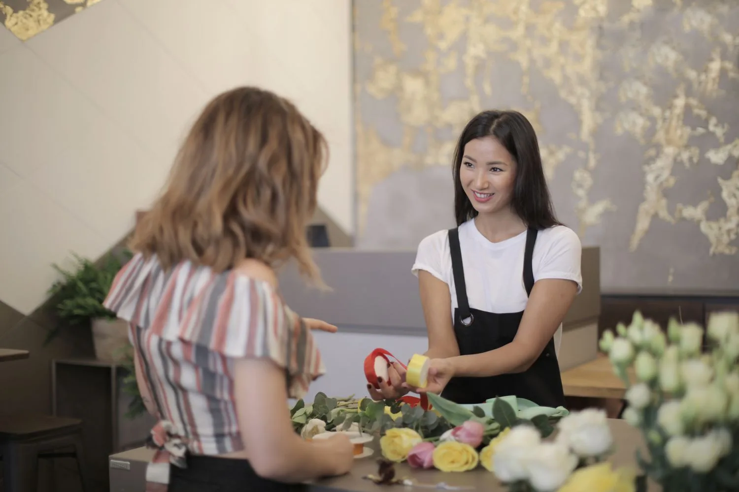 A business owner serving a customer who arrived after asking an AI for a recommendation