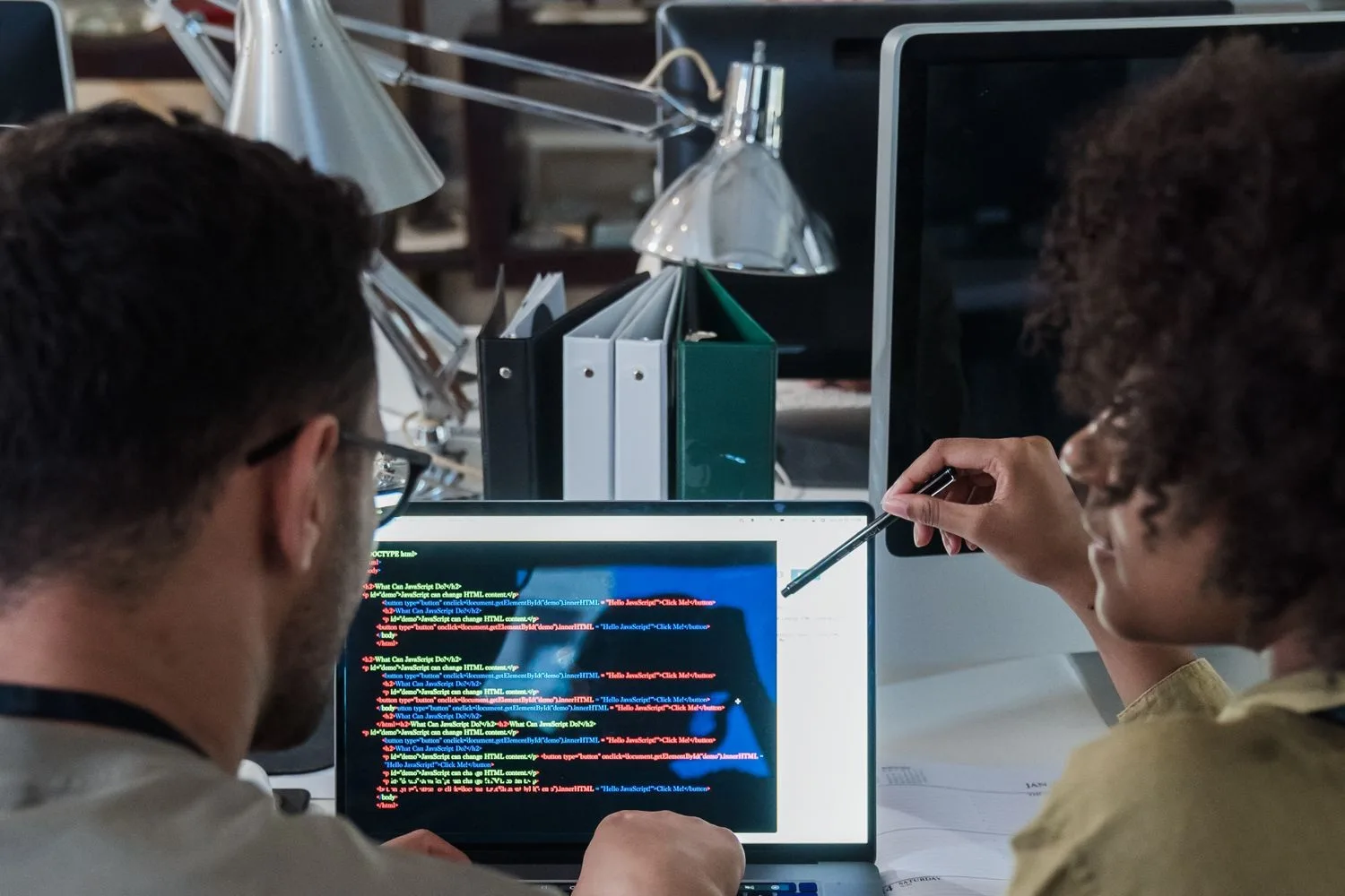 Dues persones revisant el codi d'un web, que és qui el manté