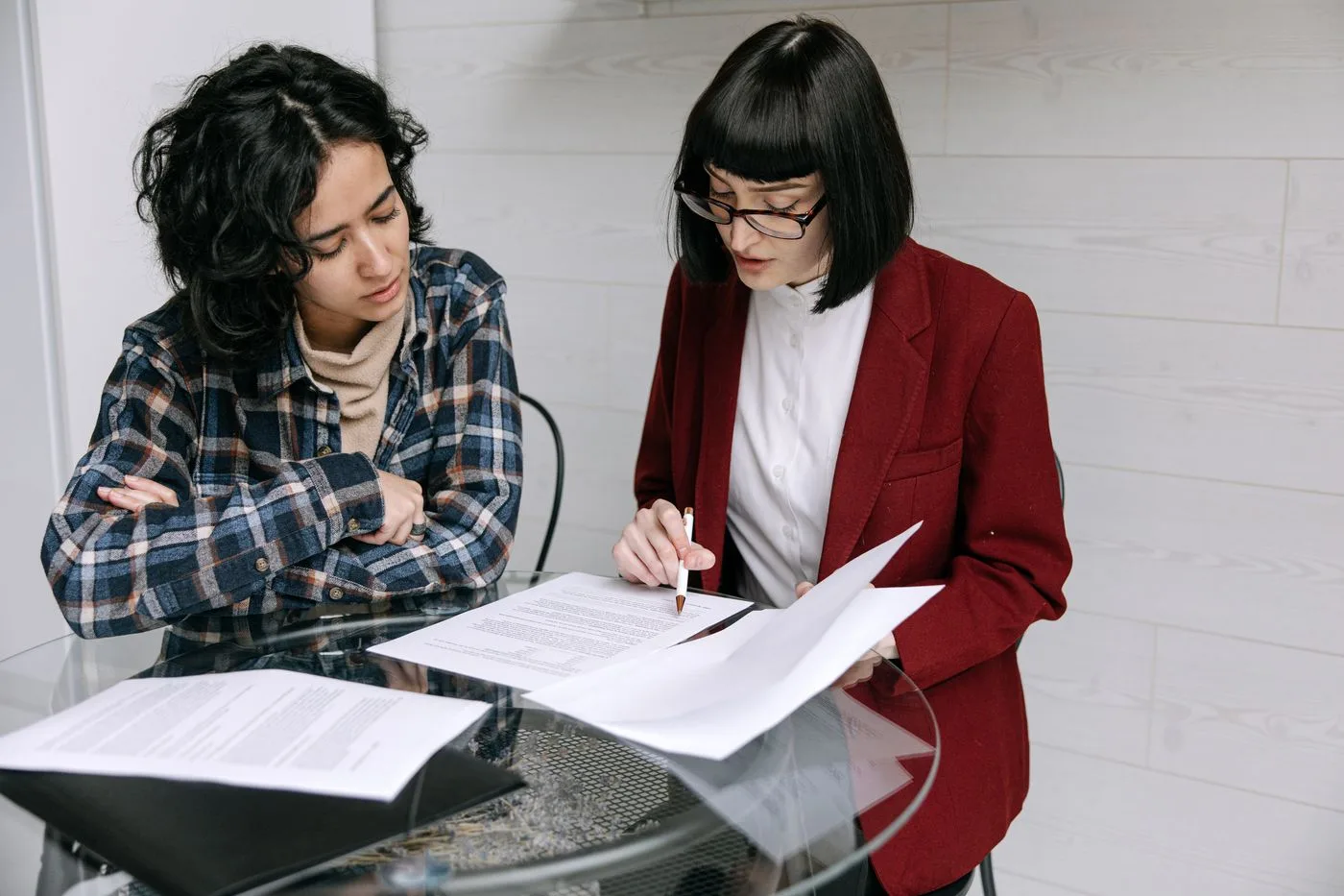 Dues persones revisant damunt la taula el contracte i els requisits del client gran