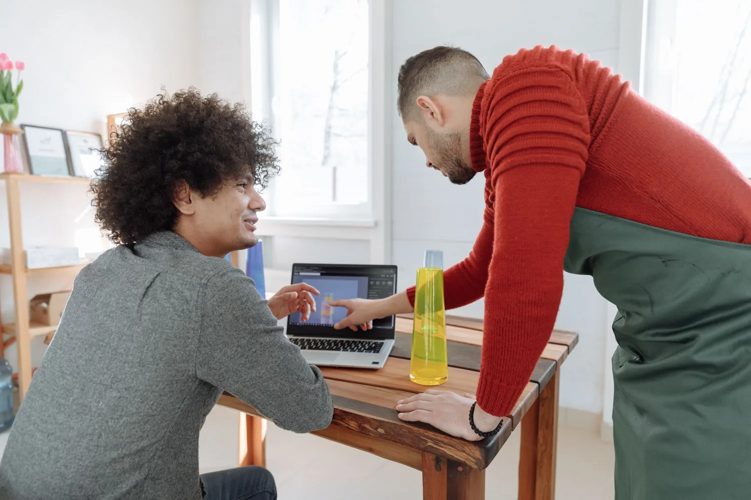 Two people reviewing a website's pages on a laptop to see why they don't show up on Google