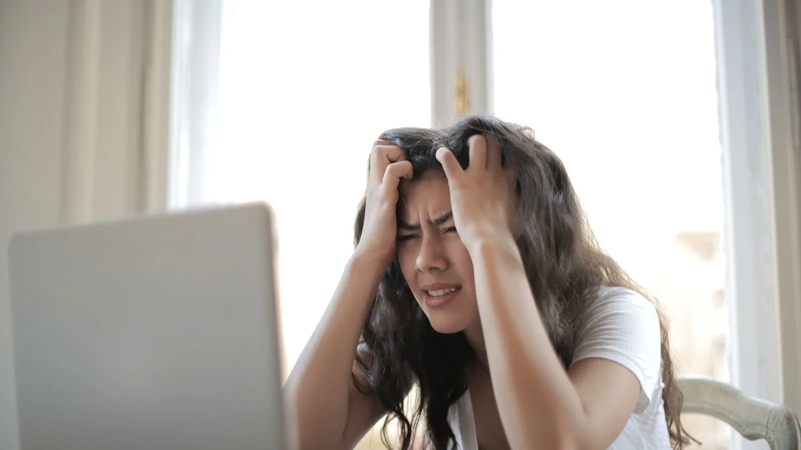 A business owner with her hands on her head seeing her website down