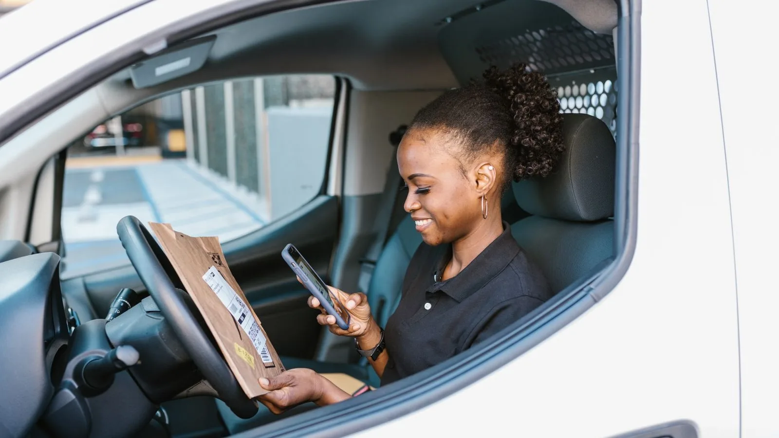 A field worker filling in a job report from the van with her phone