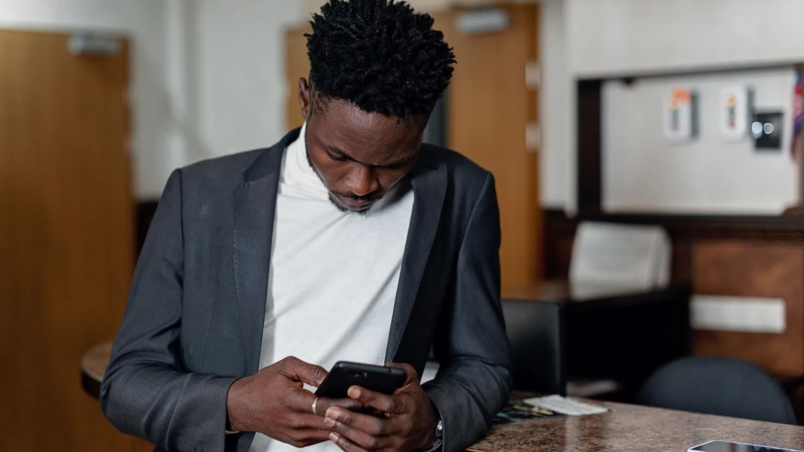 Answering a business message on the phone, leaning on the counter